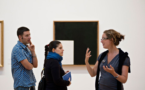 Guide med två besökare framför målning