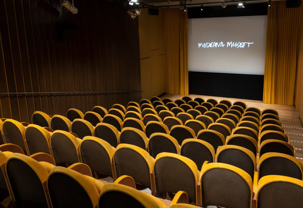 The cinema's yellow interior with cinema seats in the foreground.