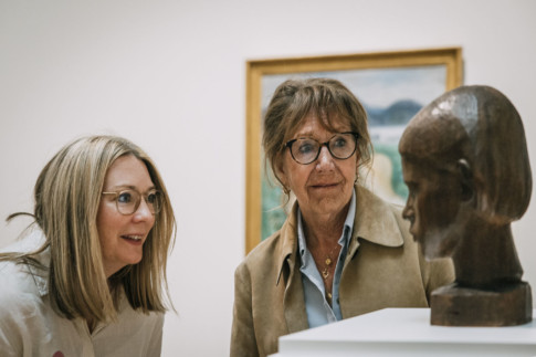 Two people looking at the sculpture Flickhuvud