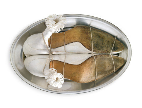 White pumps with decorations, laced up on a silver platter