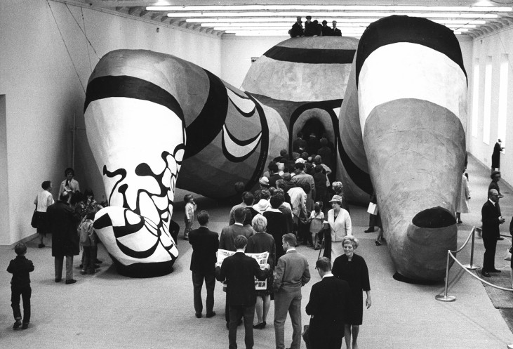 Interior with giant sculpture and audience.