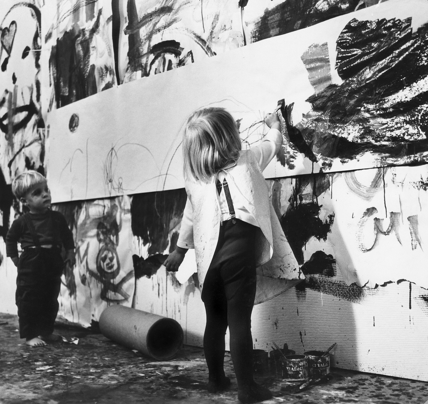 Black and white photo of child painting outdoors.
