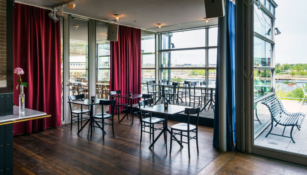 Tables and chairs in front of large windows