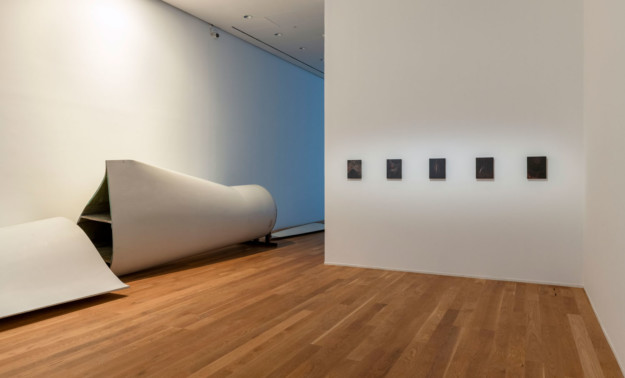 Several works of art in room with wooden floors.