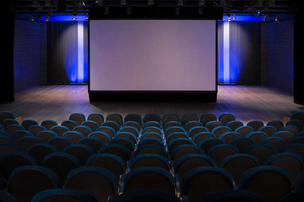 Auditoriets scen med rader av stolar i förgrunden.