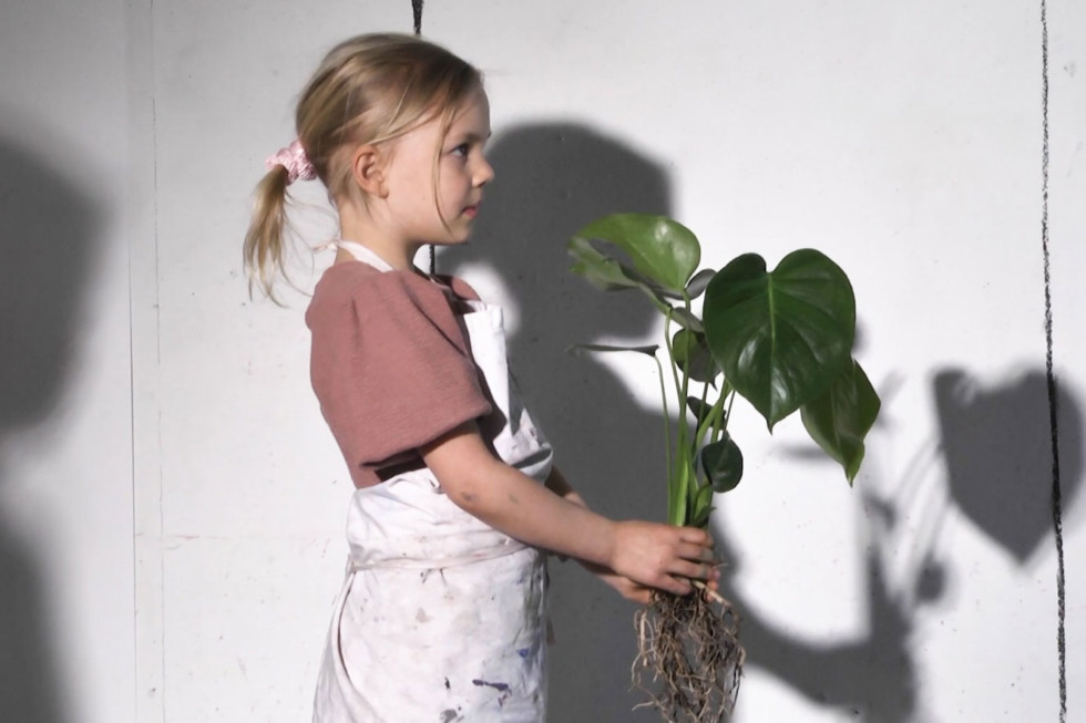 Barn med växt i händerna. Stillbild från video.