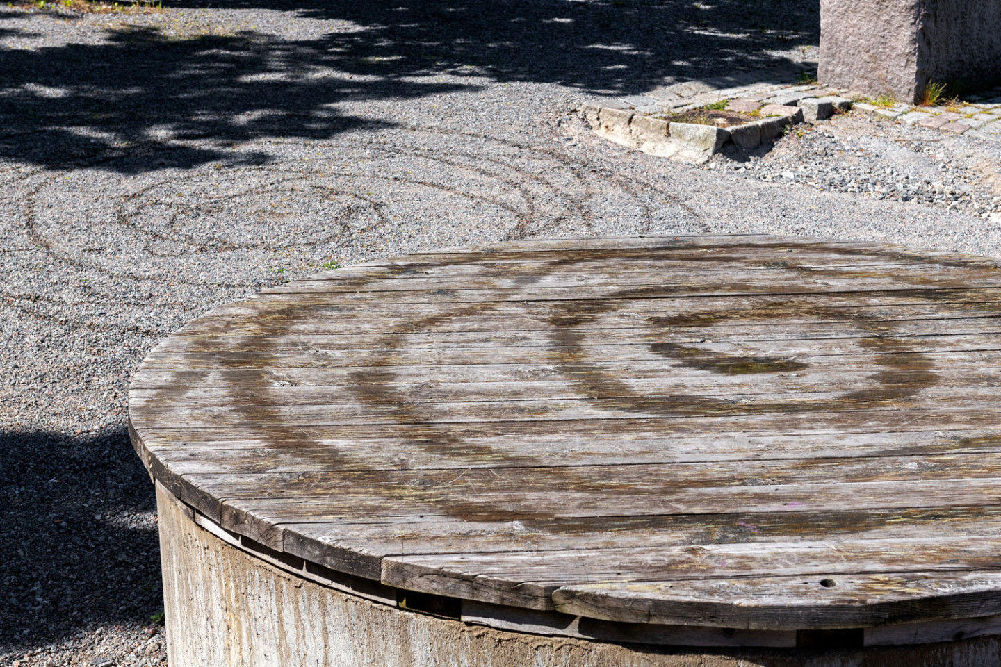 Circles in water on gravel and wood.