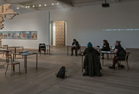 Hosts sitting at tables in exhibition area