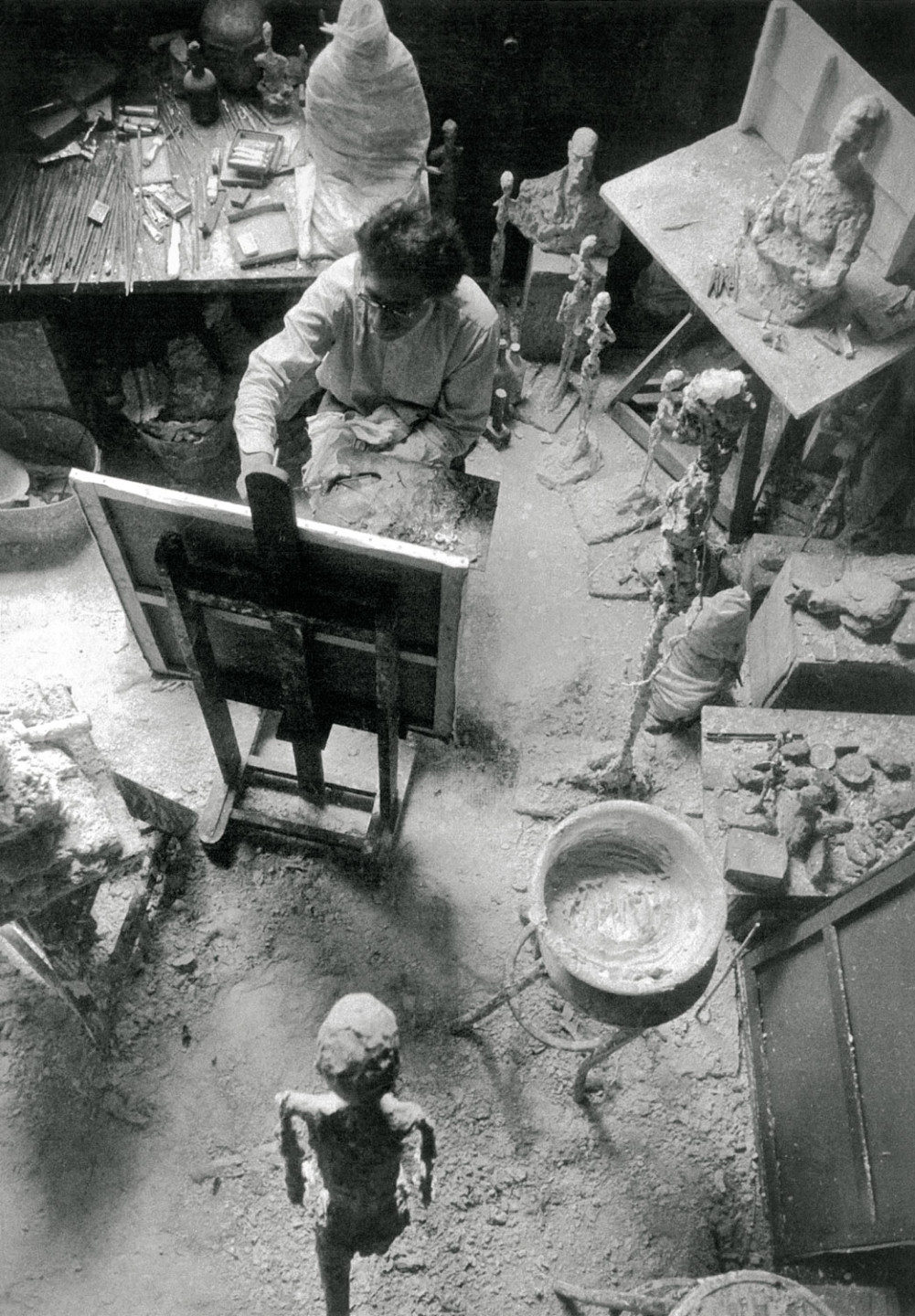 Black and white photograph of Giacometti painting in his studio
