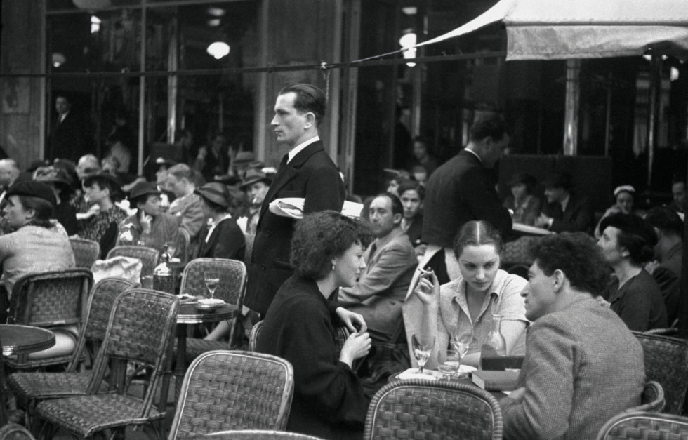 Black and white photograph of a café with guests.