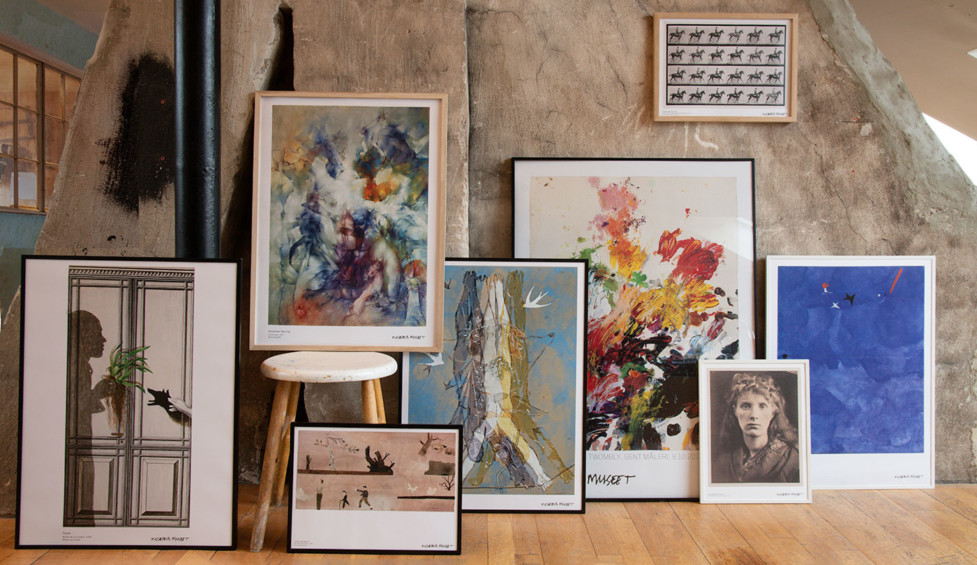 Eight posters in front of a wall