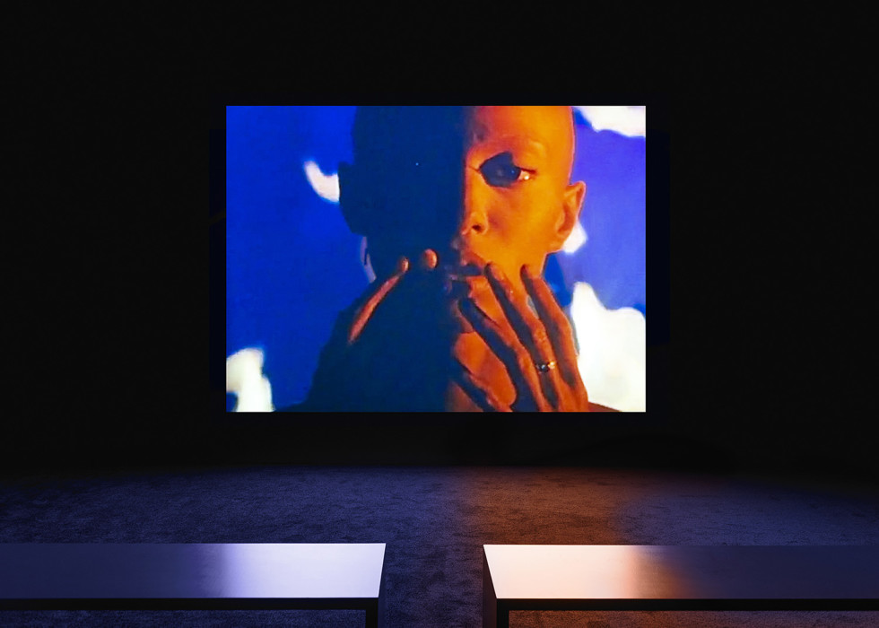 Color image projected on the wall, two benches in the foreground of the room
