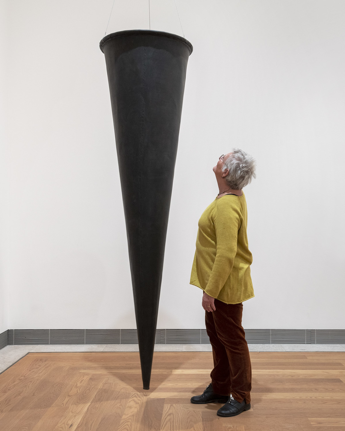 Person next to the sculpture in the exhibition