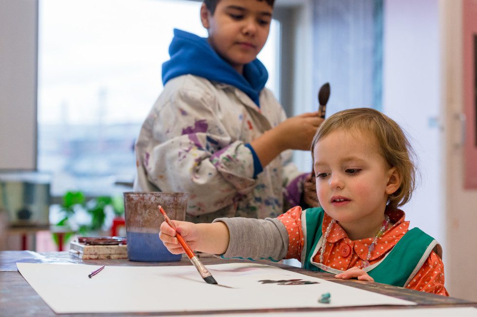Two children painting in the Workshop