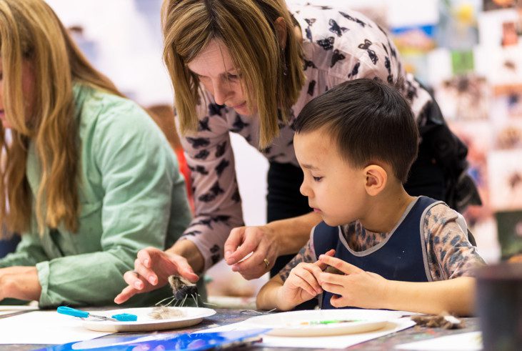 An adult is helping a child with it's craft