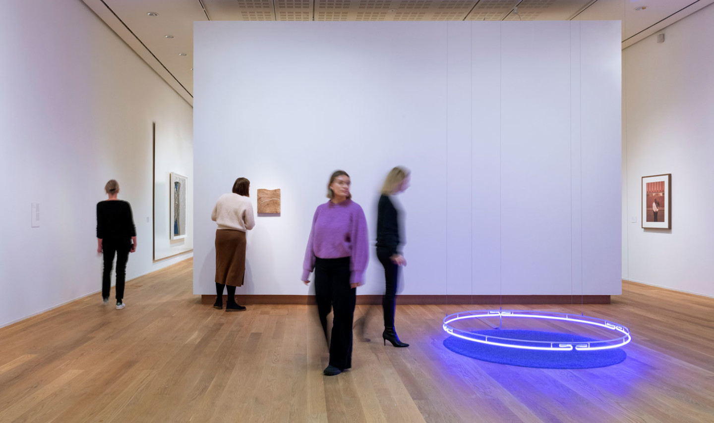 Four persons walking around in the exhibition hall