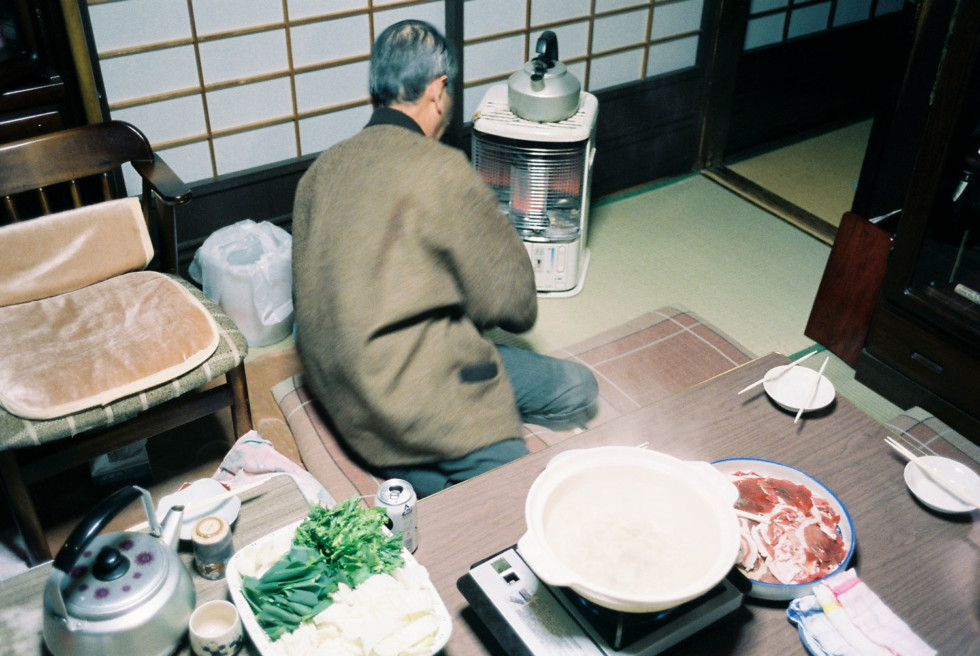 En man sitter på golvet och lagar mat