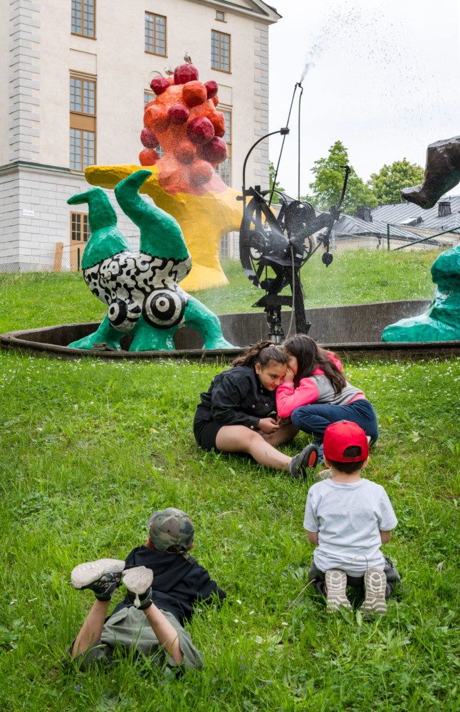 children playing in front of Paradise by Niki de Saint Phalle, Jean Tinguely