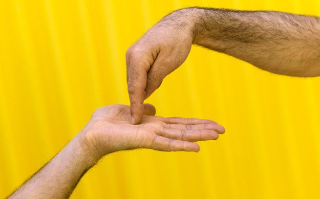 Two hands where one hand points down into an open palm