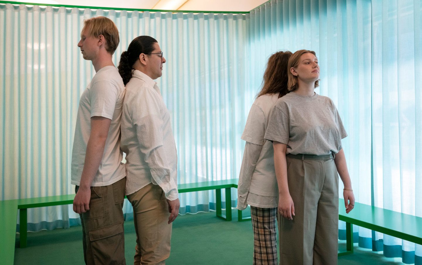 Four people standing in pairs with their backs to each other