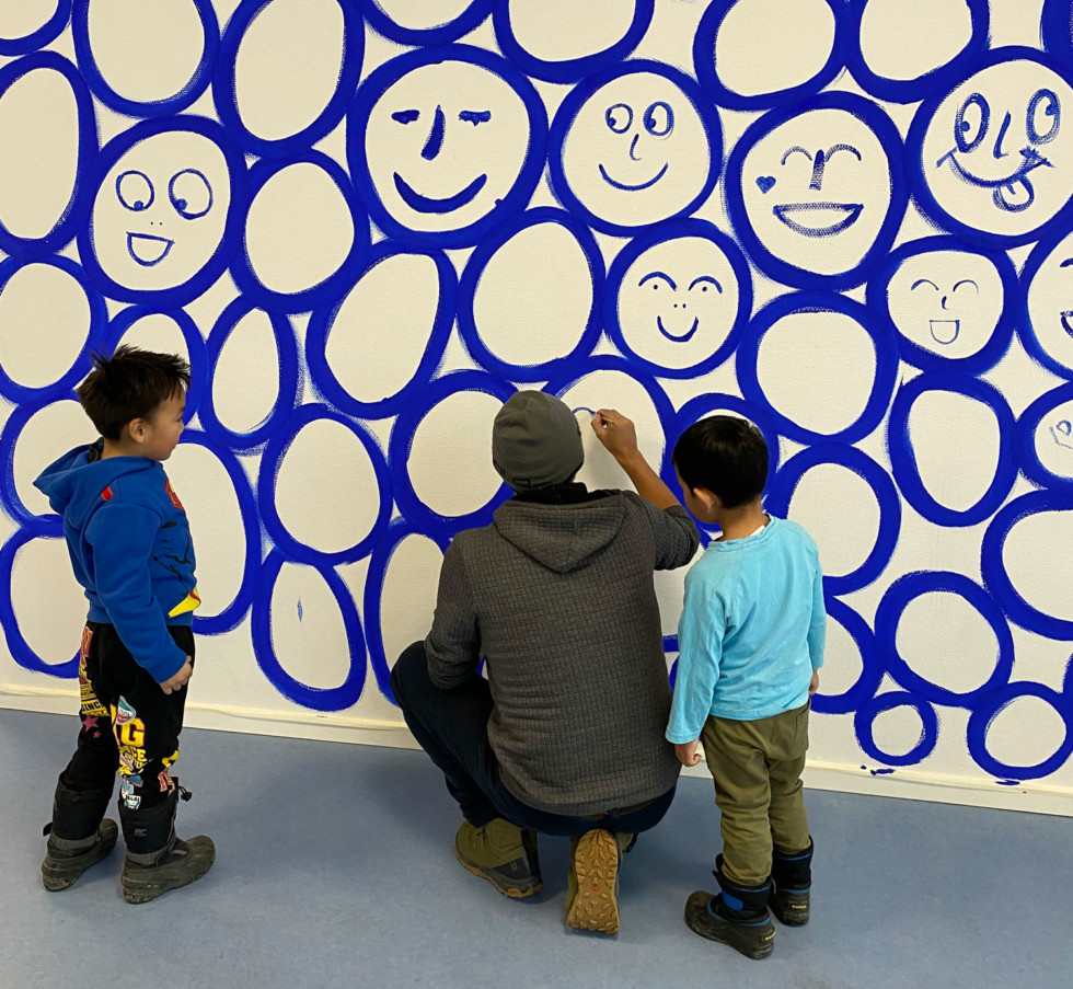 Painted faces in blue against a white background