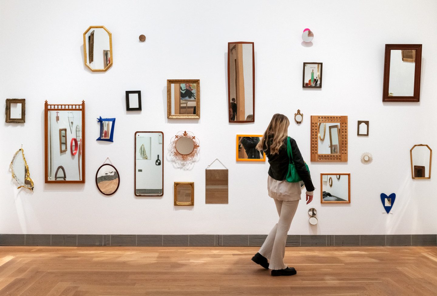 A person standing in Jeppe Hein's "Mirror Room" which consists of collected mirrors from the public