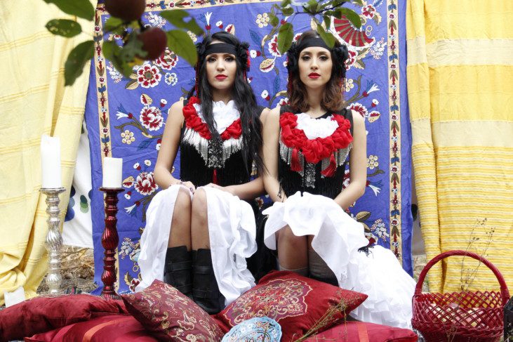 Foto av två sittande kvinnor i identisk klädsel