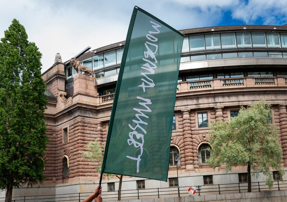 En Moderna Museet-flagga framför Sveriges Riksdag