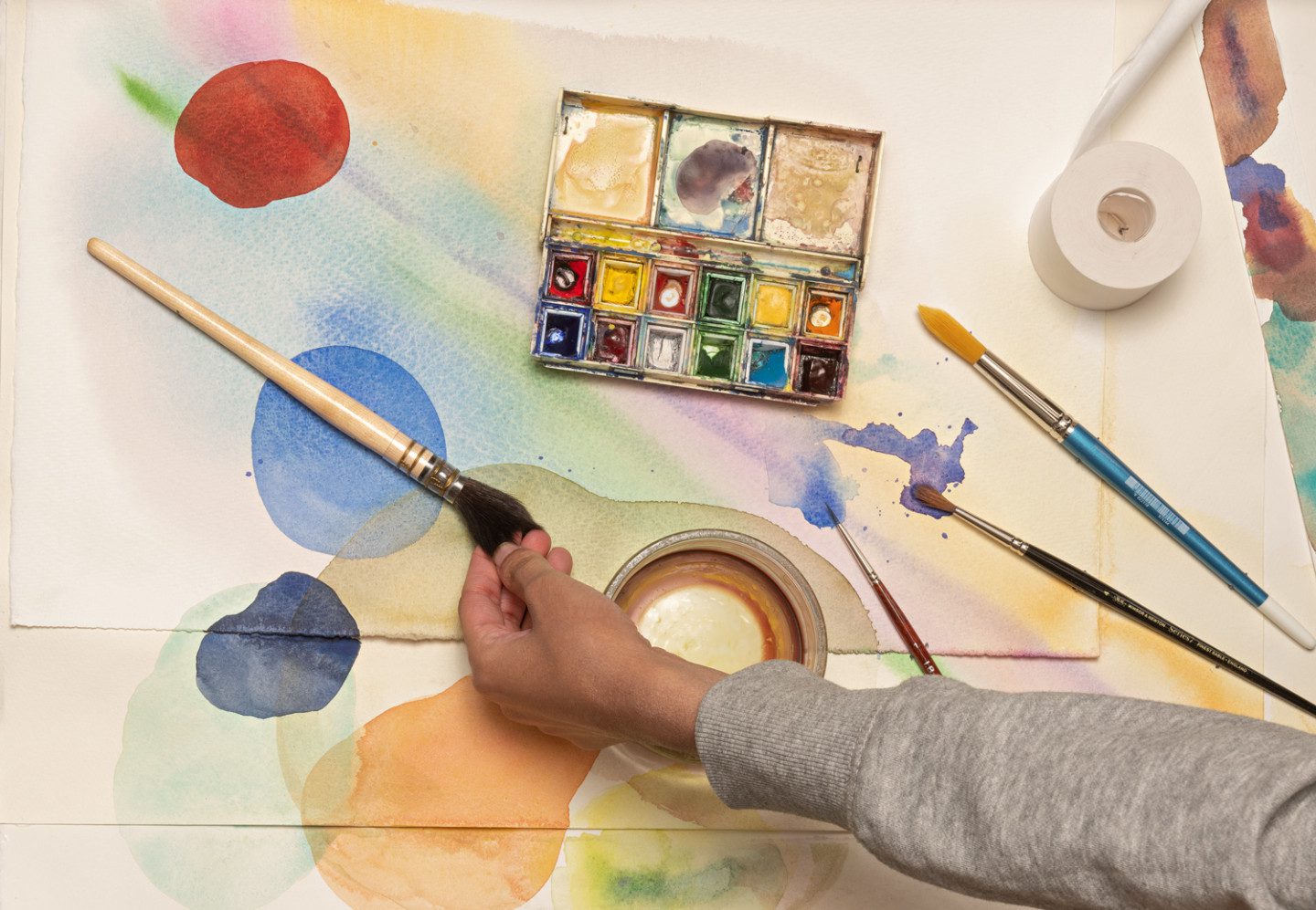 En låda med redskap och material för att måla akvarell, penslar och färgtuber