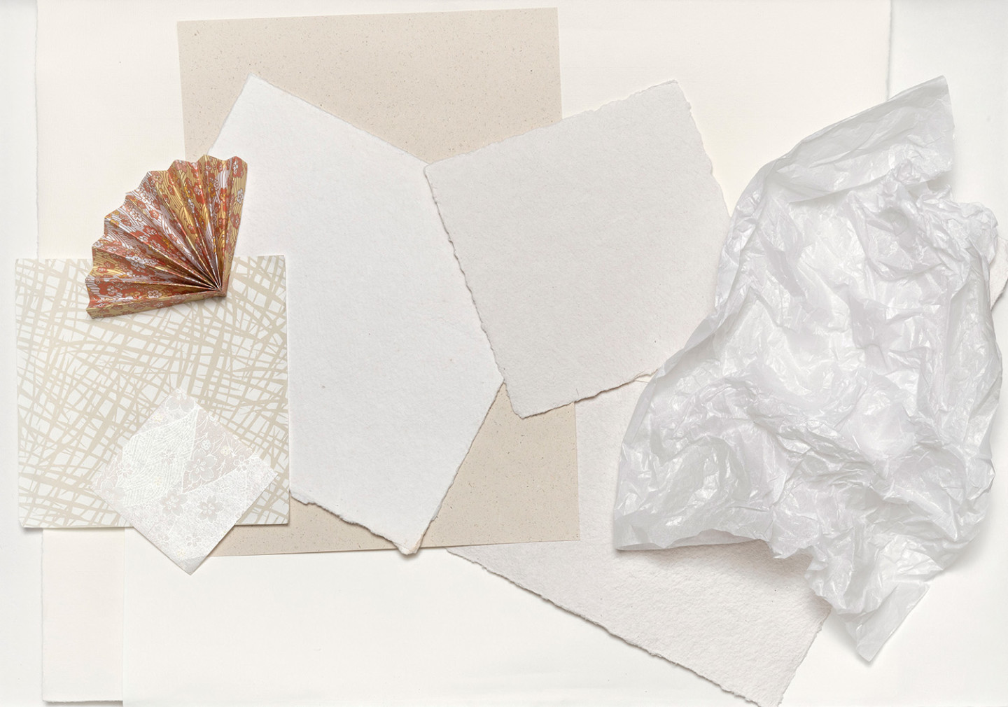  Papers of different qualities are spread out on a table.
