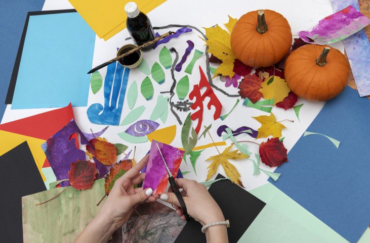 Foto med färgade papper och hand som klipper i papper