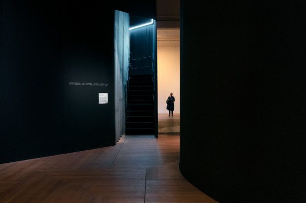 Between the rooms in the exhibition "Nan Goldin – This Will Not End Well". A person stands at the back of the picture