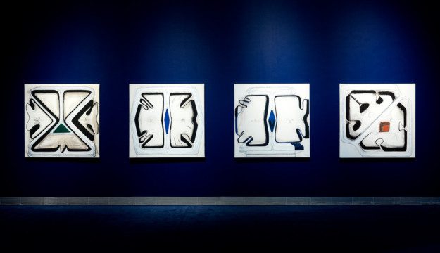 Four abstact artworks on a dark blue wall