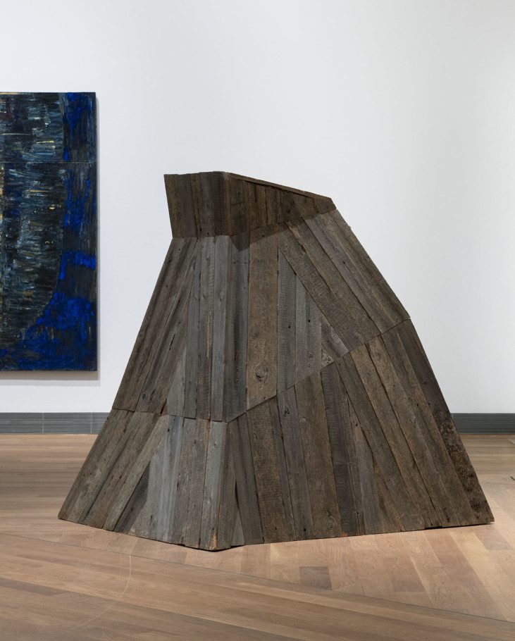 Installation view over a mountain-like sculpture made out of wood boards