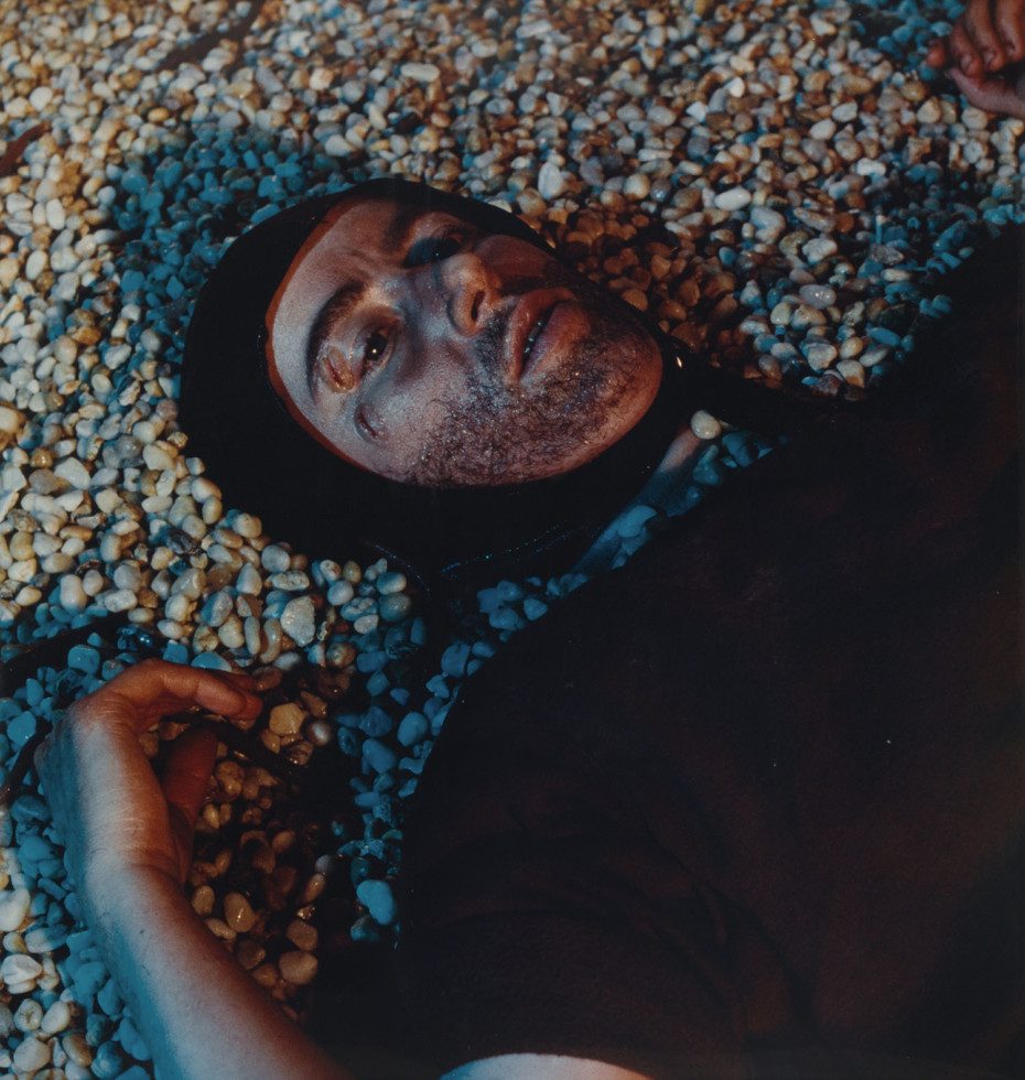 photo of person lying down in black clothes and dark stains in face