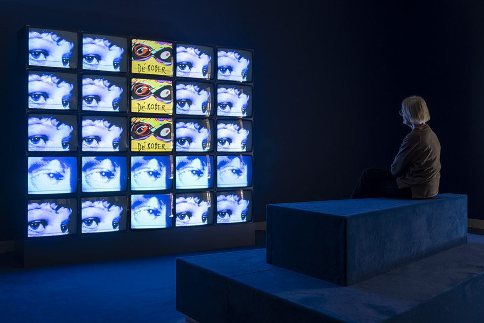 A person is sitting in front of the artwork Nuit Blanche