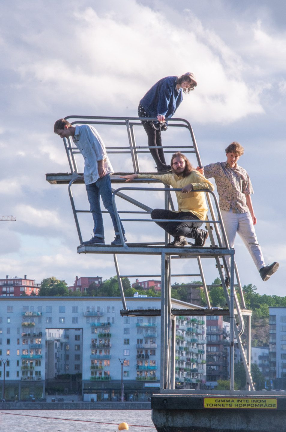 Fotografi på bandet Melby som står uppradade och poserar på ett hopptorn