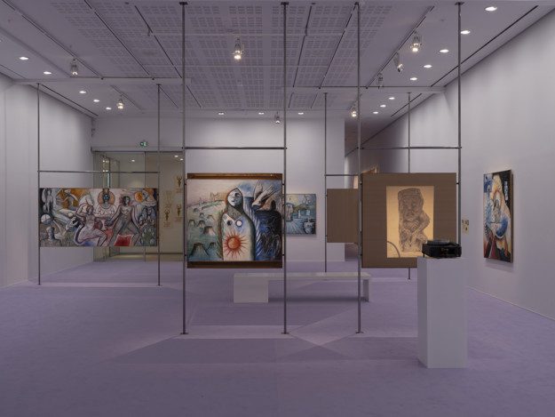 Installation view over the exhibition. Artworks are displayed on metal pipes. The room has purple walls and a purple carpet.