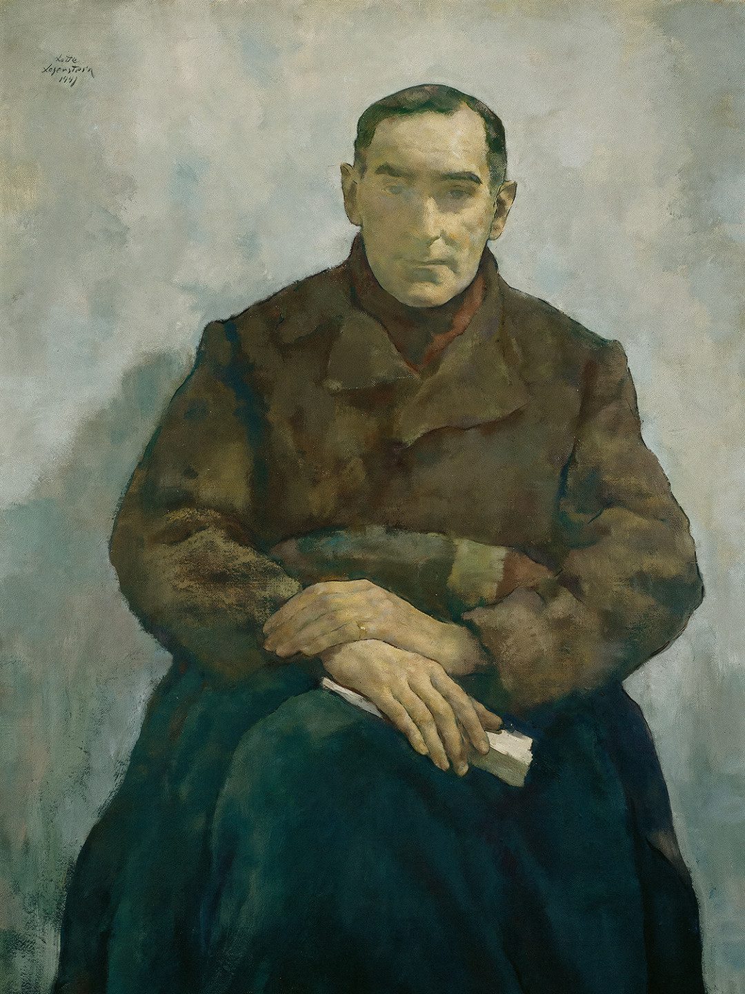 En man sittande med korsade händer