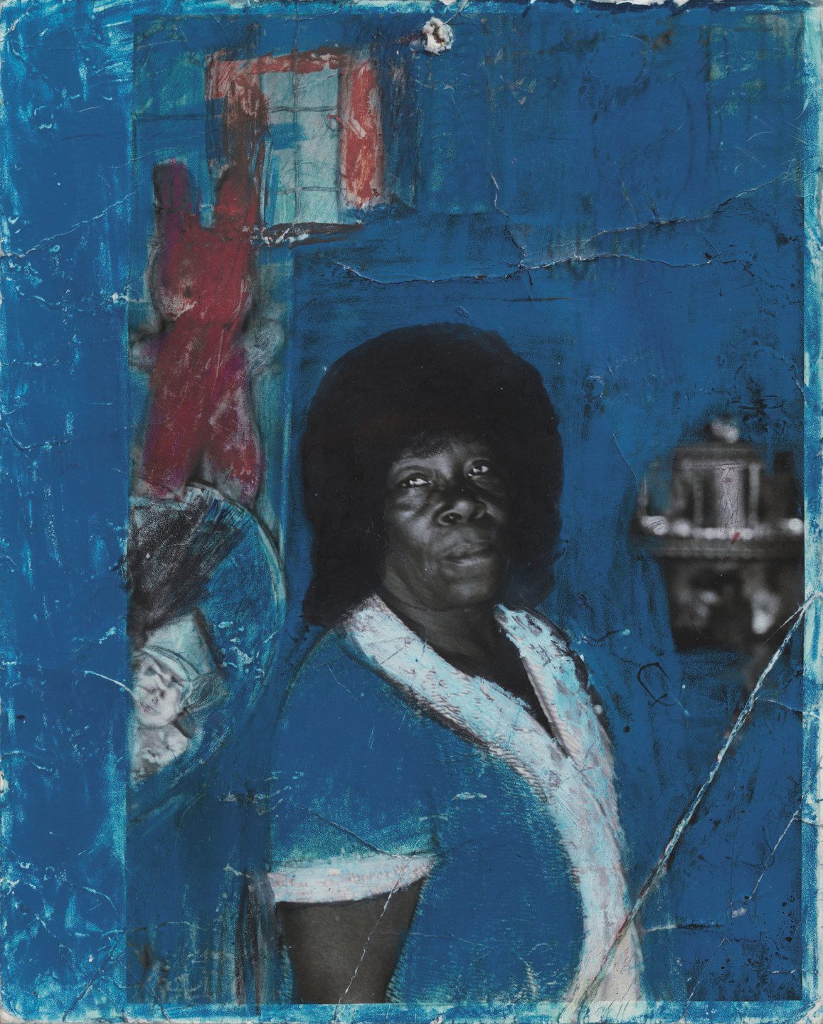 A black-and white photo of a person looking towards the camera, with blue and red paint surrounding it