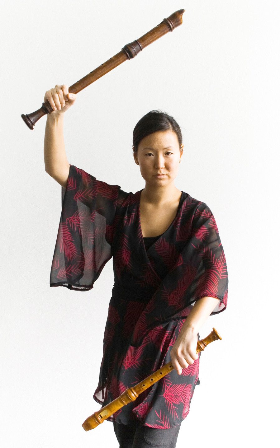 Katarina Widell holding two flutes with a plain background