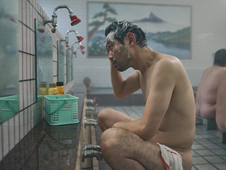 a man sitting in a public shower room