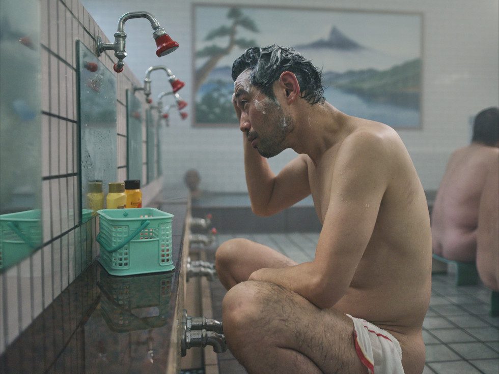 a man sitting in a public shower room