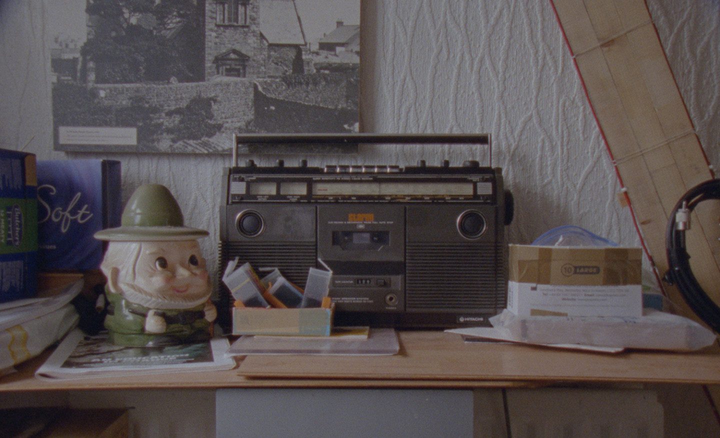 a desk with a clutter of things, and a recorder is centered on the table