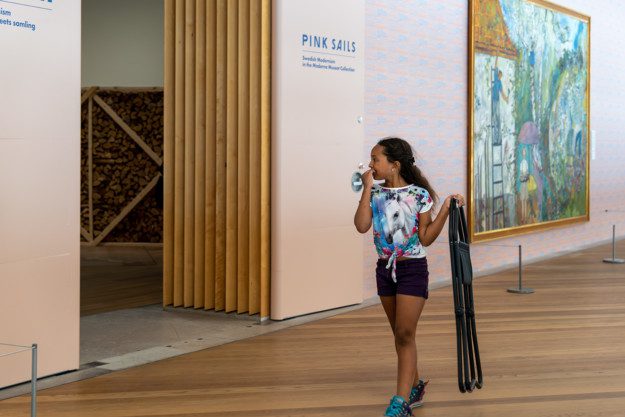 ett barn är på väg in i utställningen Rosa segel