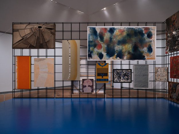 Paintings hung on an iron grid in the exhibition room "the Salon"