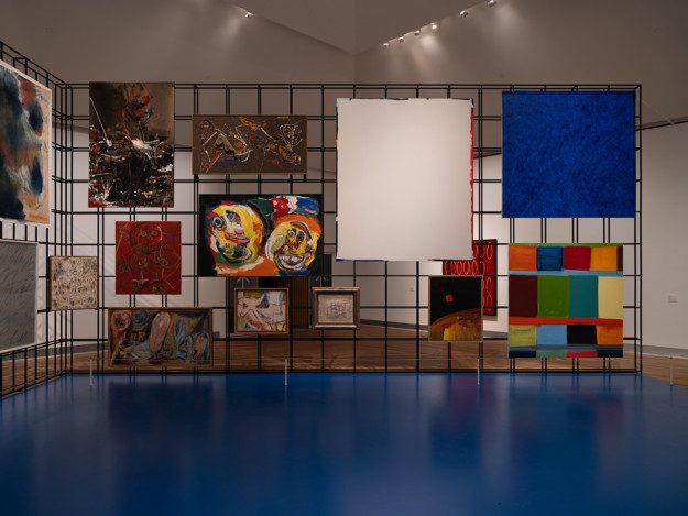 Paintings hung on an iron grid in the exhibition room "the Salon"