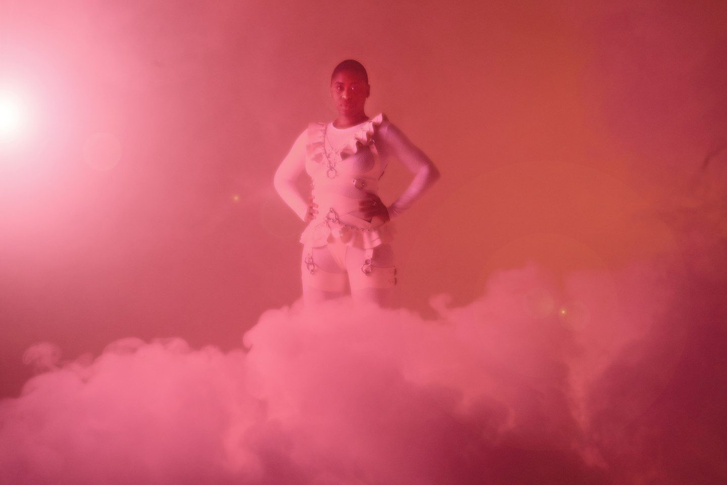 Film still from Bodily Remains, a person standing in a pink cloud