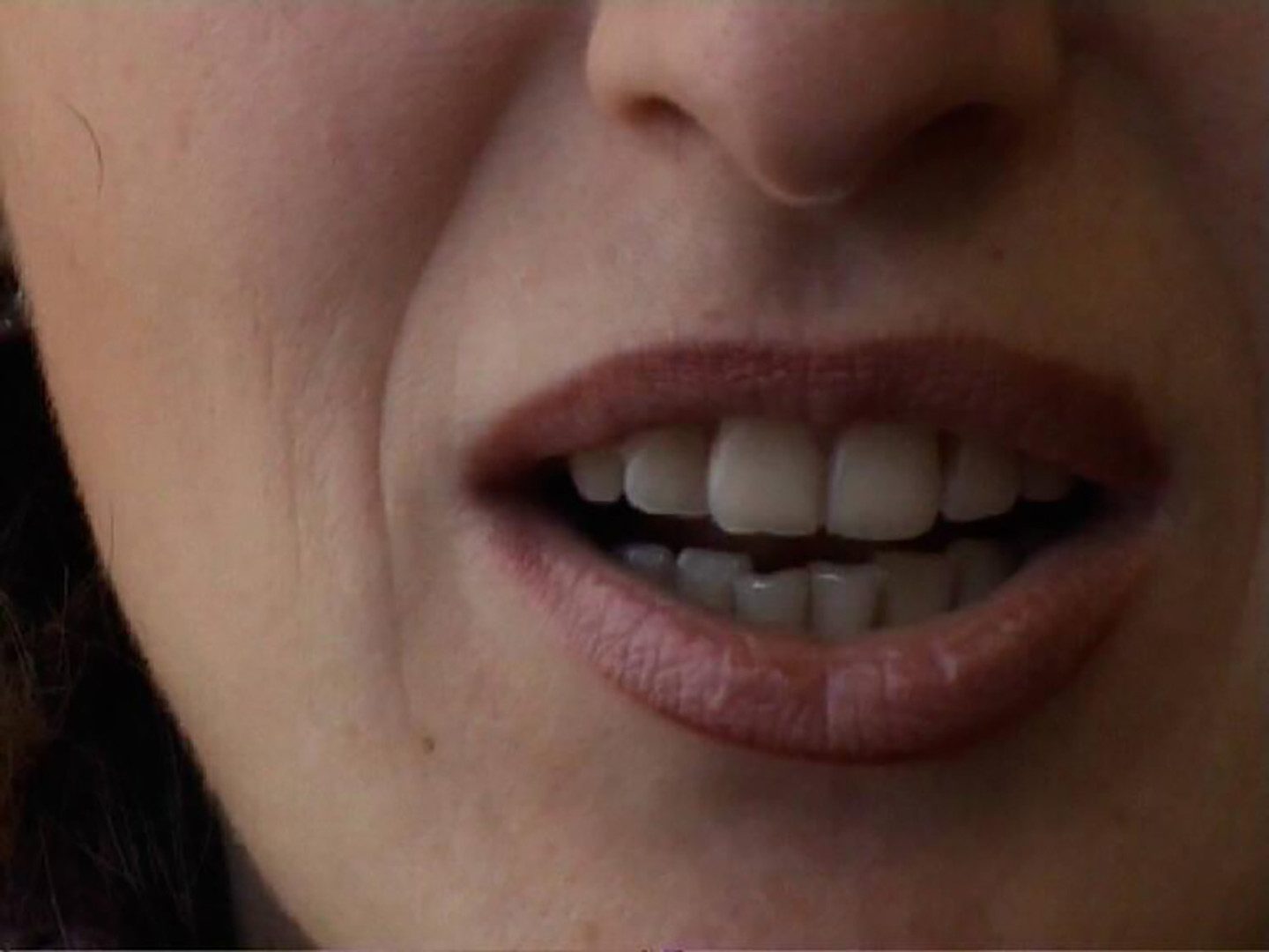 closeup of a mouth in the middle of a sentence, teeth showing