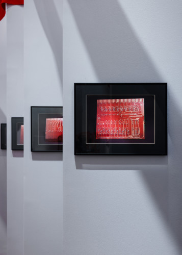 artworks with motifs in red and black frames 